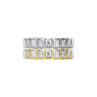 Two gold and silver rings with emerald-cut gemstones on a white background