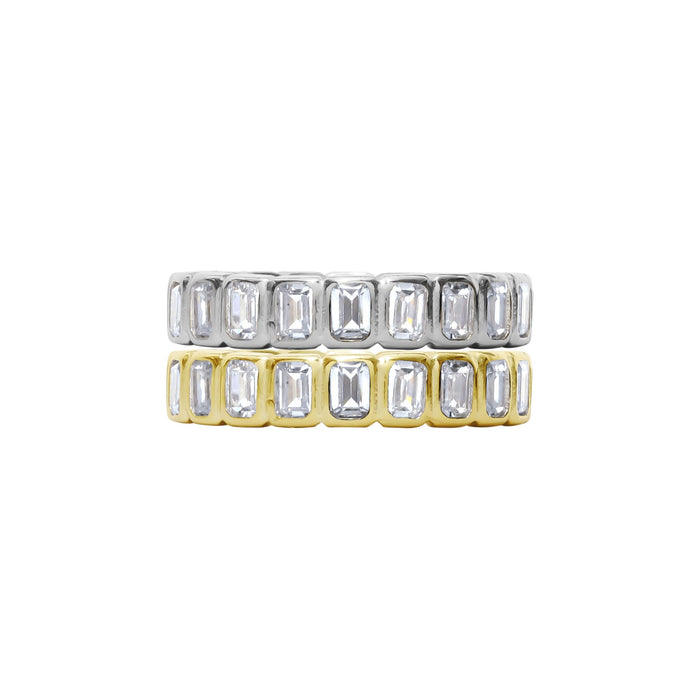 Two gold and silver rings with emerald-cut gemstones on a white background