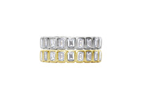 Two gold and silver rings with emerald-cut gemstones on a white background
